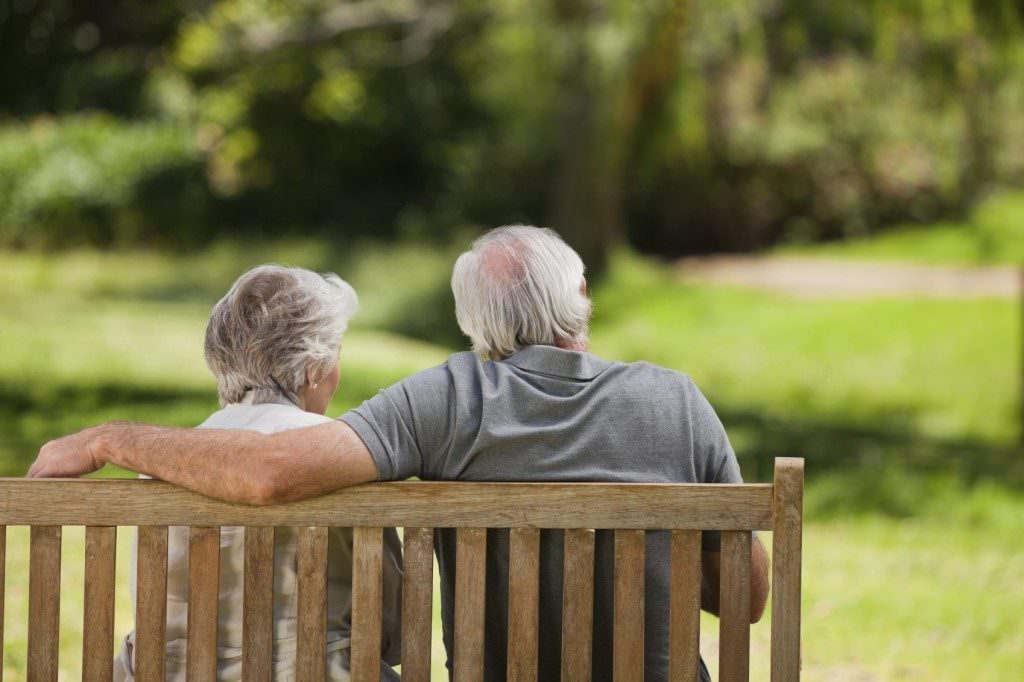 Elderly Couple Sitting On The Park Bench